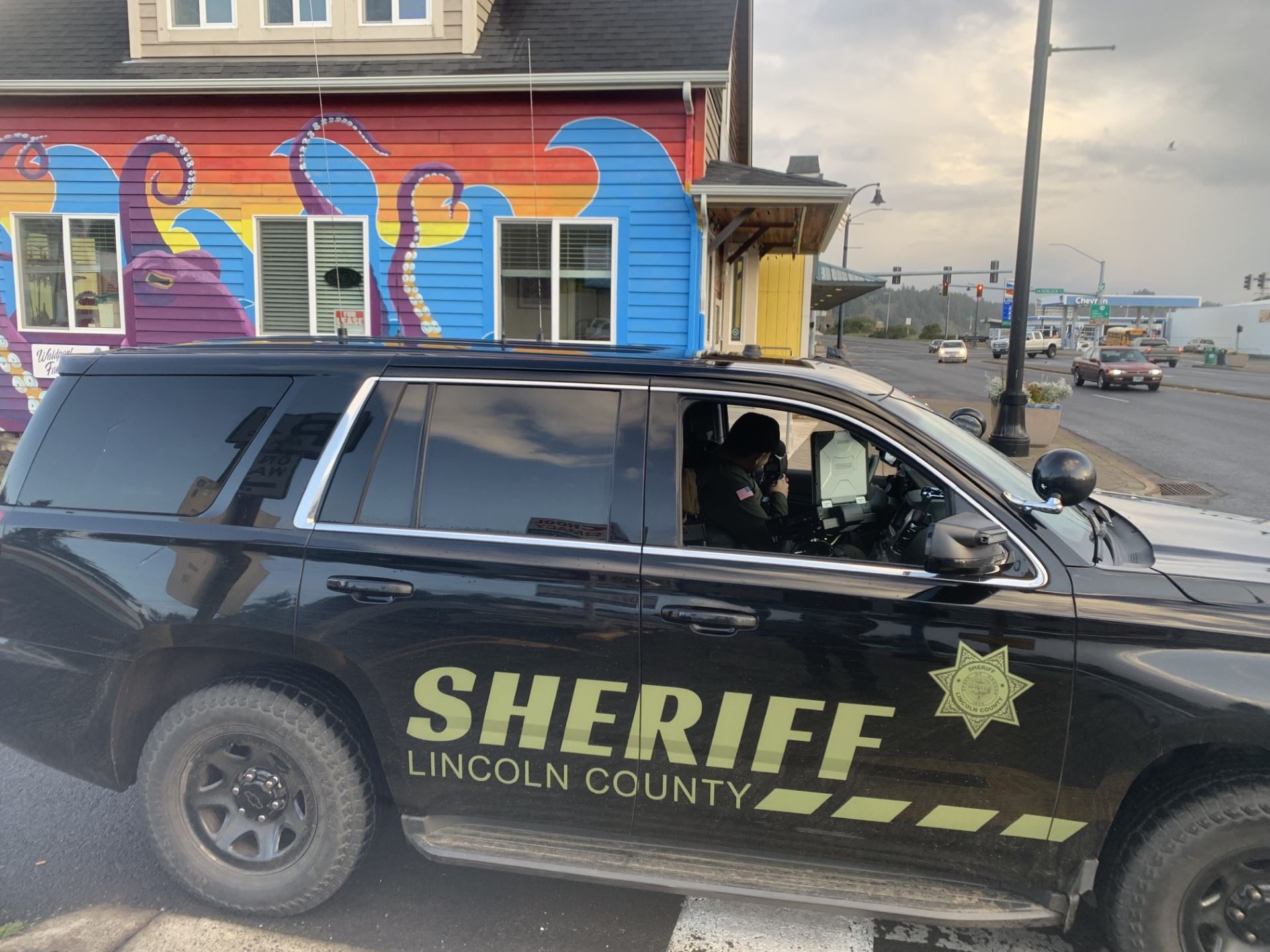Deputy sitting in car with radar gun pointed at traffic. 